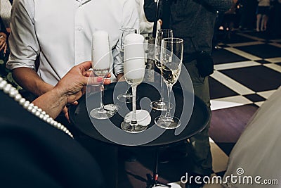 people toasting with champagne glasses at wedding reception, waiter serving on tray champagne drinks, celebration catering Stock Photo