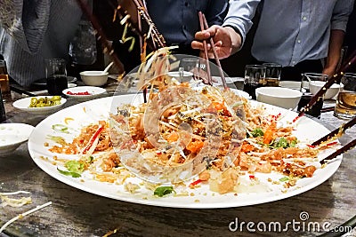 People tossing yee sang or yusheng during Chinese New Year Stock Photo