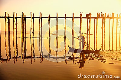 People traveling across the U Bein Bridge in the evening. Mandalay Myanmar with sunset Editorial Stock Photo