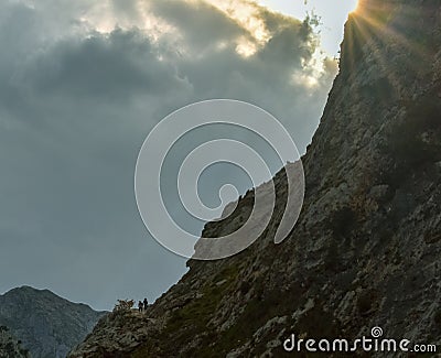 People on a trekking route with peaks at the bottom at sunset, Asturias Stock Photo