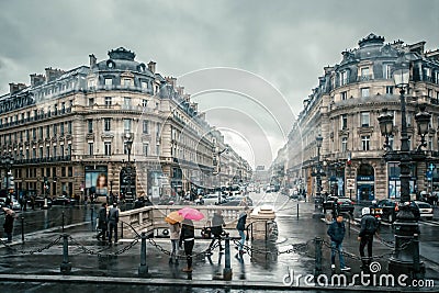 People under colored umbrellas run in the rain on the streets of Paris, France Editorial Stock Photo