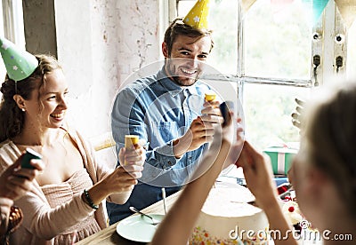 People Using Party Popping on Friend Birthday Celebration Stock Photo