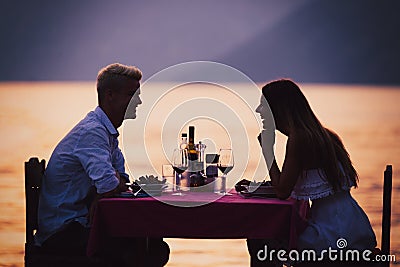 People, vacation, love and romance concept. Young couple enjoying a romantic dinner on beach. Stock Photo