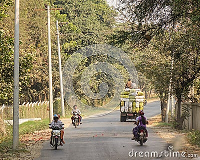 People and vehicles on rural road in Mandalay, Myanmar Editorial Stock Photo