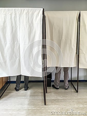 People voting in polling booths at a voting station Stock Photo