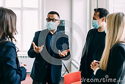 People vs covid. Young business company manager and team of responsible employees care about clients and coworkers wearing Stock Photo