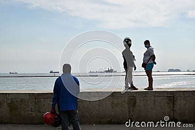 People wait on queue on bay walk to view the artificially face lifted beach coast line dumped with white dolomite sand. silhouette Editorial Stock Photo