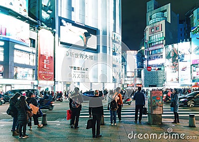 People waiting for crossing the road on crosswalk with lights from buildings in the background at Ximending area in Taiwan, Taipei Editorial Stock Photo