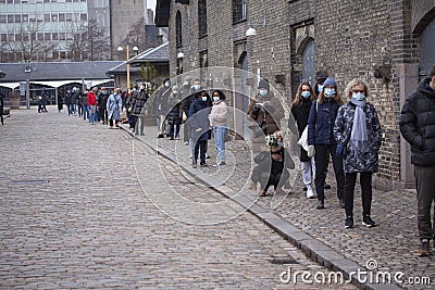 People waiting in line queued up for health screening for Coronavirus Covid-19 testing at city test center wearing medical protect Editorial Stock Photo