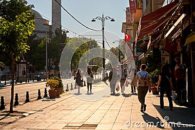 People walk along the sidewalk at Sultanahmet Square in Istanbul Editorial Stock Photo
