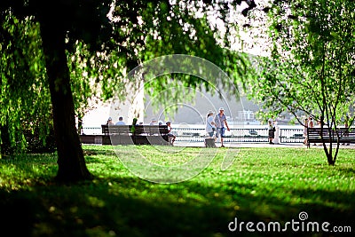 People walk along the waterfront beautiful green lawn Editorial Stock Photo