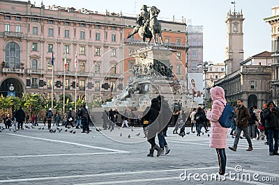 People walk on the main square of the city of Milan - Piazza del Duomo near the monument to the first king of Italy Vittorio Editorial Stock Photo