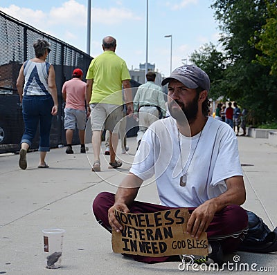 People walk past homeless veteran Editorial Stock Photo