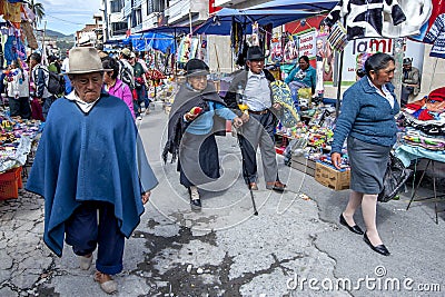People walk past the many stalls at the Indian market in Otavalo in Ecuador. Editorial Stock Photo
