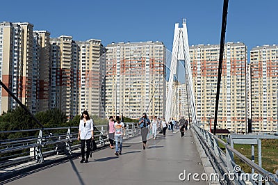 People walk on the Pavshinsky pedestrian bridge over the Moscow river in Krasnogorsk near Moscow Editorial Stock Photo