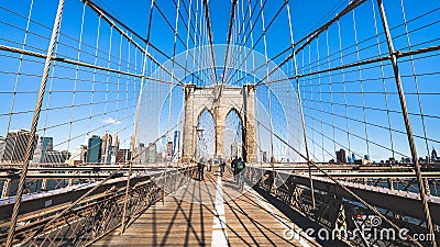 People walk and ride bicycle on Brooklyn bridge in New York City, sunny day. United states tourism landmark, American city life Editorial Stock Photo