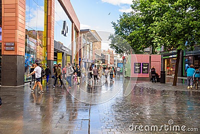 People walking along a pedestrian street lined with shops and restaurants in Liverpool city centre Editorial Stock Photo