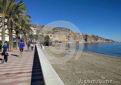 People walking along the seafront promenade of Aguadulce. Spain Editorial Stock Photo