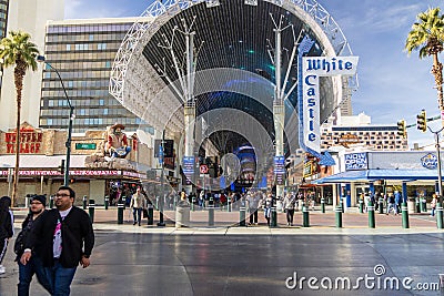 People walking along the street at the Fremont Street Experience with restaurants and retail stores and a video screen ceiling Editorial Stock Photo