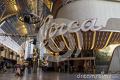 People walking along the street at the Fremont Street Experience with restaurants and retail stores and a video screen ceiling Editorial Stock Photo