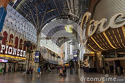 People walking along the street at the Fremont Street Experience with restaurants and retail stores and a video screen ceiling Editorial Stock Photo