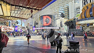 People walking along the street at the Fremont Street Experience with restaurants and retail stores and a video screen ceiling Editorial Stock Photo