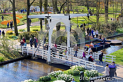 People walking on bridge over water canal in beautiful Keukenhof Garden, Holland Editorial Stock Photo