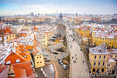 People are walking on Charles bridge, whose rooftops are covered by snow, Prague in the winter Editorial Stock Photo