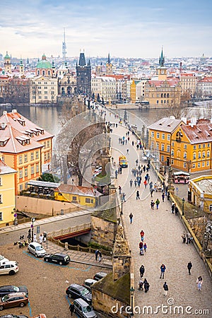 People are walking on Charles bridge, whose rooftops are covered by snow, Prague in the winter Editorial Stock Photo