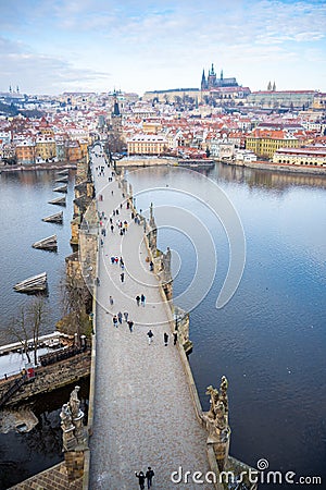 People are walking on Charles bridge, whose rooftops are covered by snow, Prague in the winter Editorial Stock Photo