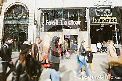 People walking in front of Foot Locker store with protected closed showcase windows entrance on Champs Elysees avenue Editorial Stock Photo