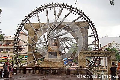 People are walking nearly the ancient wooden water wheel Editorial Stock Photo