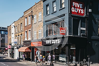 People walking past Five Guys restaurant in Richmond, London, UK Editorial Stock Photo