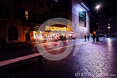 People walking in Piazza Navona by night. Scene with bright purple lights Editorial Stock Photo