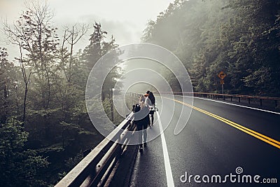 People walking on the side of the road in mountains forest Editorial Stock Photo