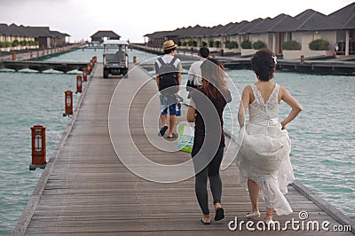 People walking at timber pier Maldives Editorial Stock Photo