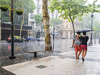 People walking with umbrellas in heavy rainstorm in city centre Editorial Stock Photo