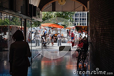 People walking via tunnel toward market stall in central Strasbourg during the Editorial Stock Photo