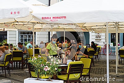 People wandering and having lunch at local restaurants on the streets of Sibiu old town during coronavirus crisis. Sibiu, Romania Editorial Stock Photo