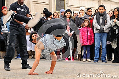 People watch a homeless streetdancer doing breakdance and dance moves in the streets of Paris to earn some money Editorial Stock Photo