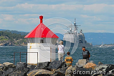 People watch military ship passing by the fjord in Frogn, Norway. Editorial Stock Photo