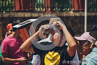 People watching the annular solar eclipse in Mexico with special observation glasses Editorial Stock Photo