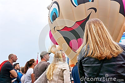 People watching a large large balloon with smiling face Editorial Stock Photo