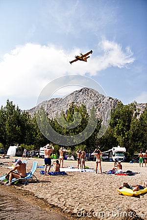 People watching and making photos of firefighters airplane in action Editorial Stock Photo