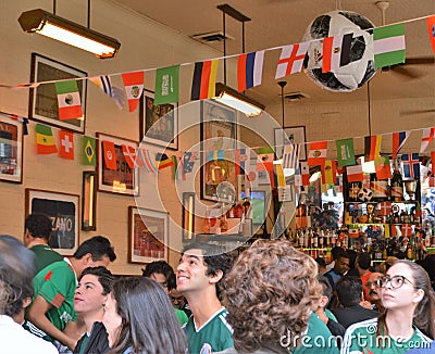 People Watching Soccer in a Restaurant Bar Editorial Stock Photo