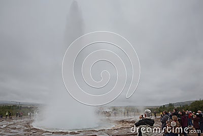 People watching Strokkur, one of the most famous geysers located in a geothermal area beside the Hvita River in the southwest part Editorial Stock Photo