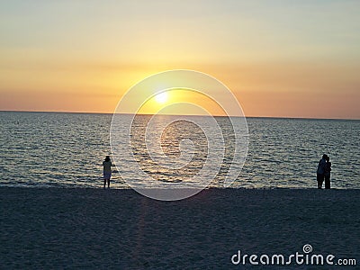 People Watching sunset on the beach. Stock Photo