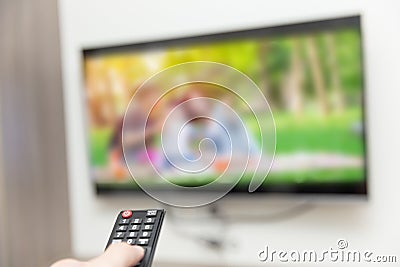 People watching tv hand with remote control Stock Photo