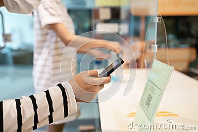 People wear face mask using the phone to scan QR code payment or register before entering and exiting in stores at the shopping Stock Photo