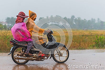 People wear packable raincoats while ride a scooter Editorial Stock Photo